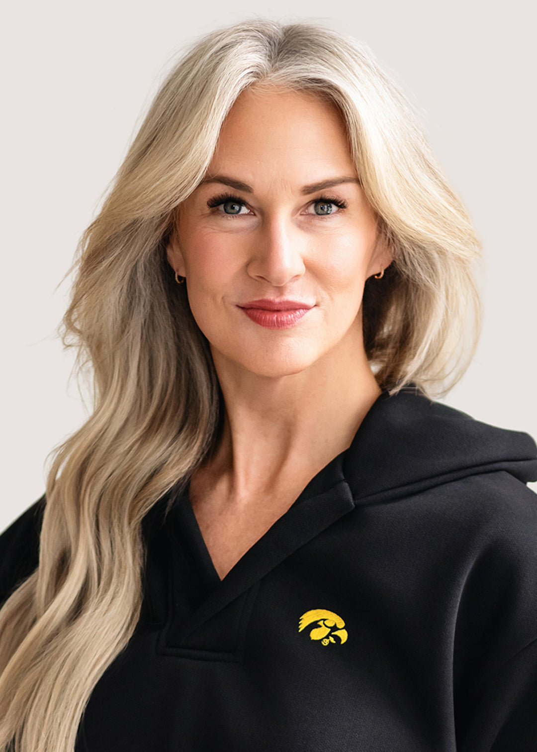 Woman wearing a black hoodie with a gold Tigerhawk logo.