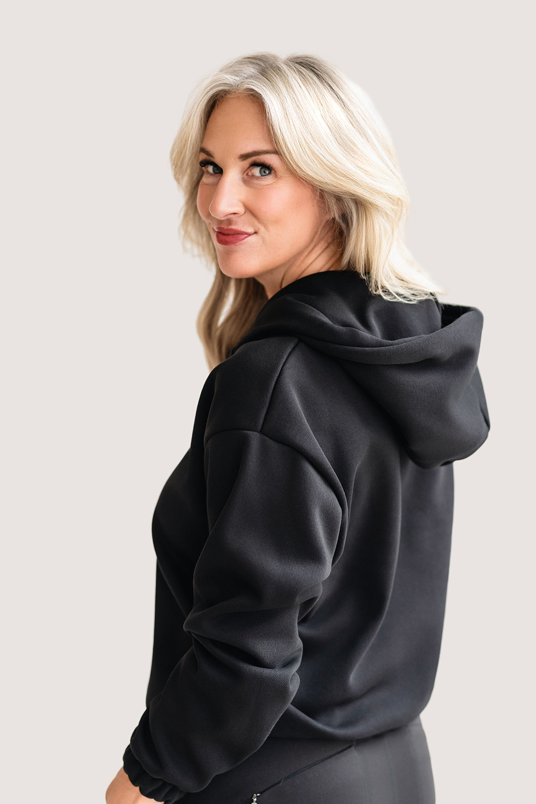Woman wearing a black hoodie.