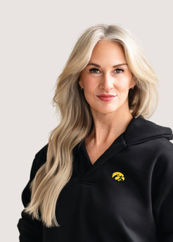 Woman wearing a black hoodie with a gold Tigerhawk logo.
