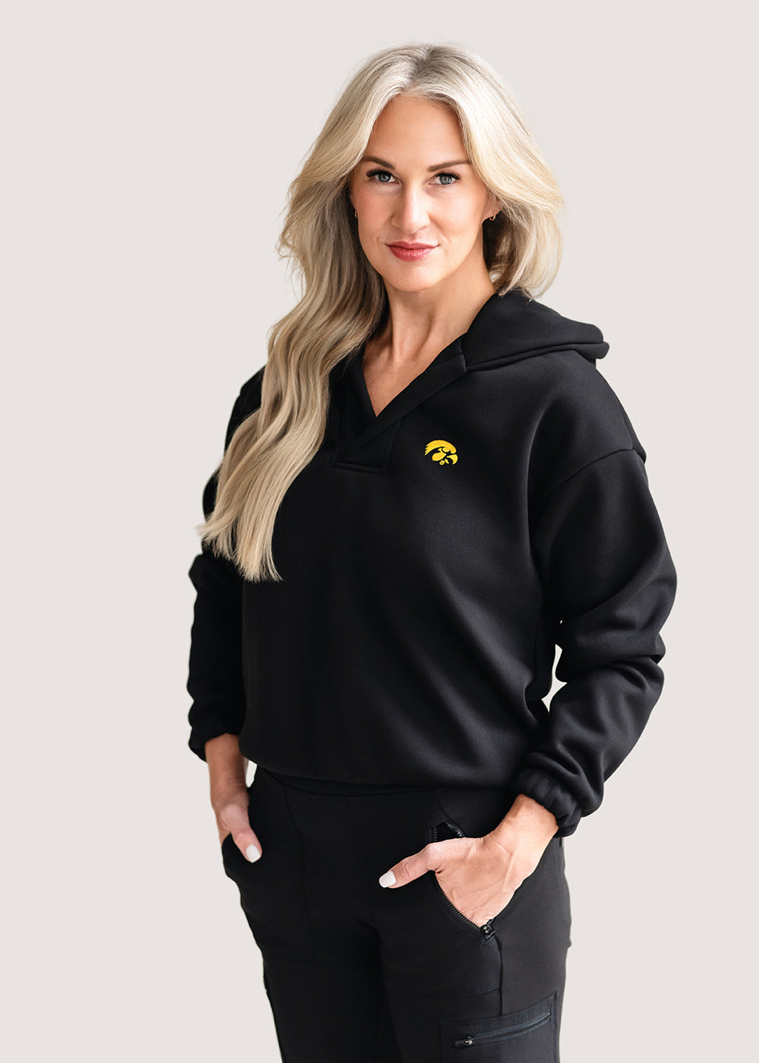 Woman wearing a black hoodie with a gold Tigerhawk logo.