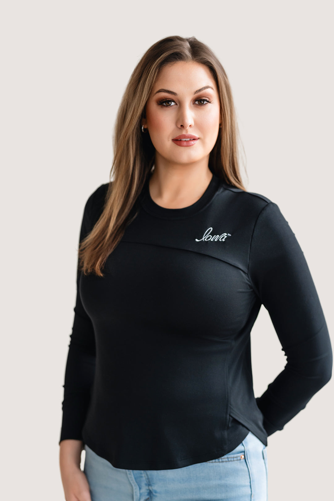Woman wearing a long sleeve black shirt with a white Iowa script logo.