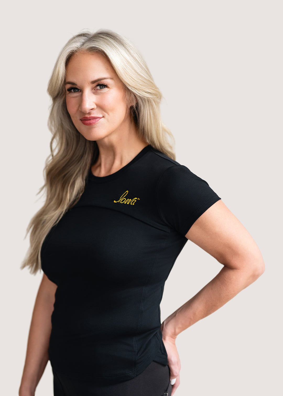 Woman wearing a short sleeve black shirt with a gold Iowa script logo.