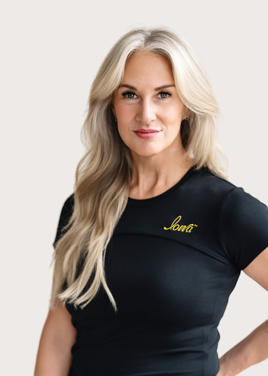 Woman wearing a short sleeve black shirt with a gold Iowa script logo.